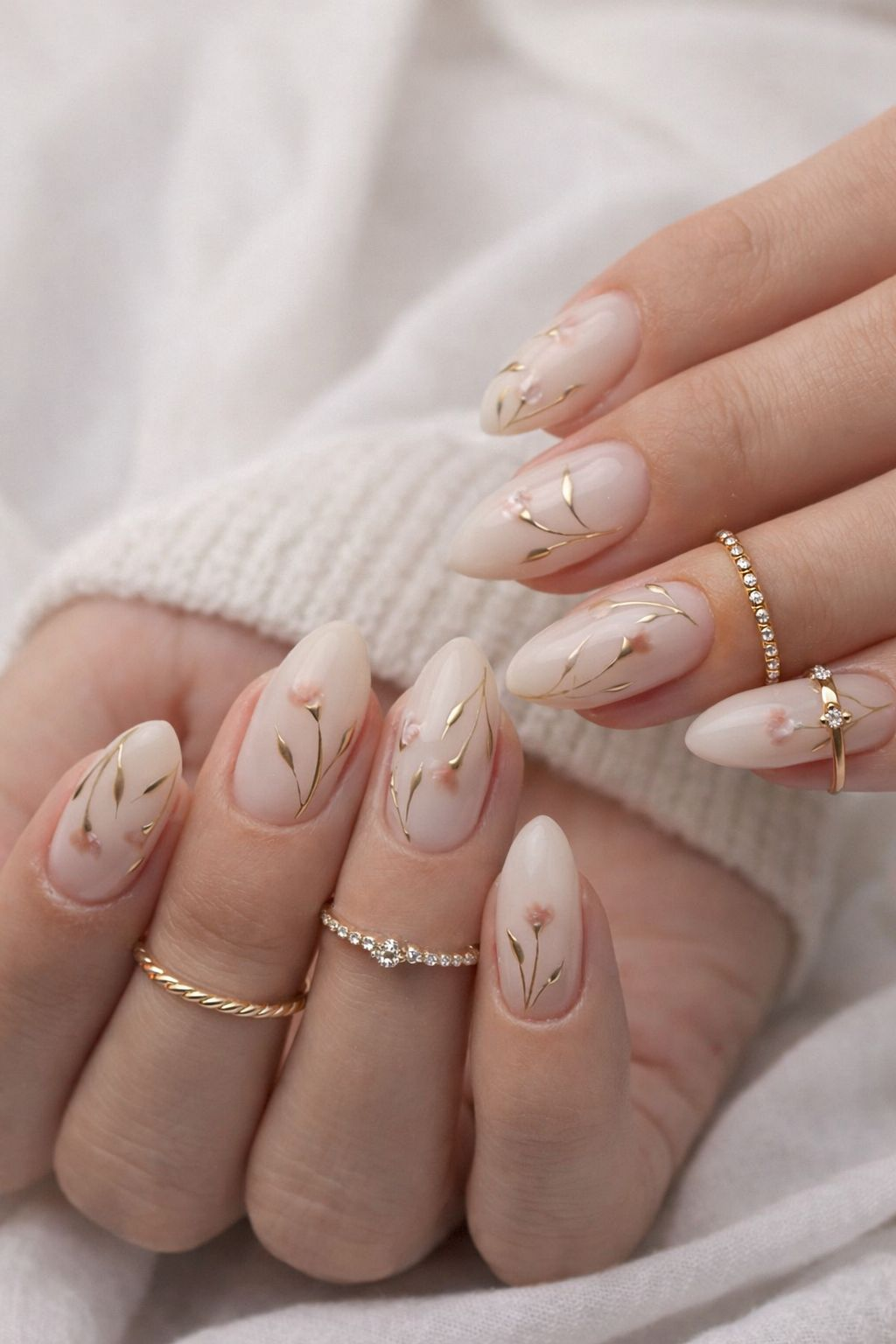 Filigrane Nageldesigns in zartem Nude mit goldenen Blüten